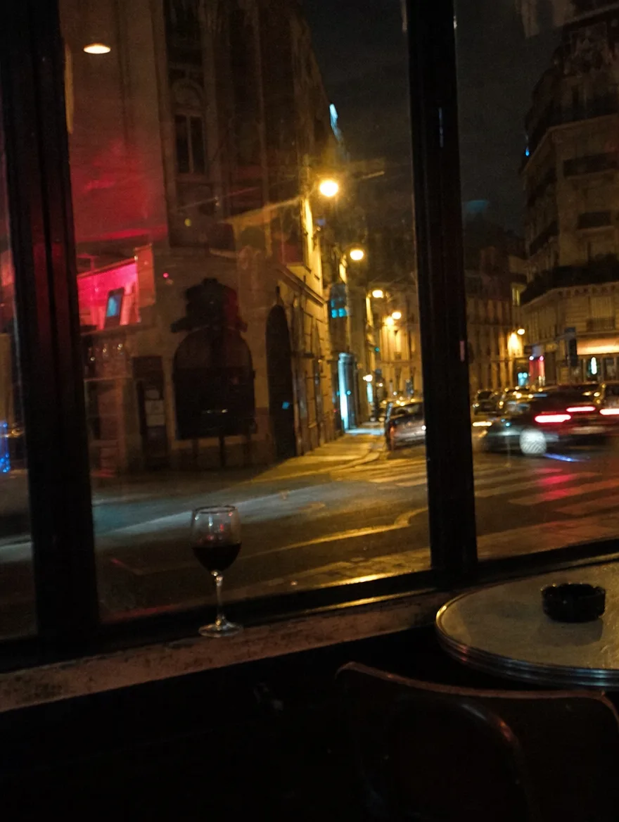 Kieliszek na parapecie knajpy, ulica za szybą.